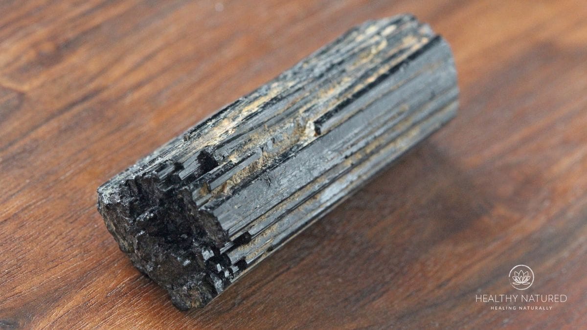 black tourmaline stone on a wooden backdrop